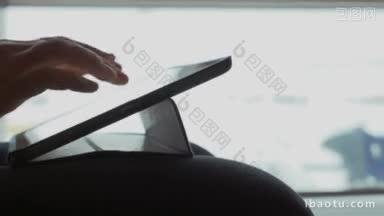 特写镜头中，一名女子坐在窗边等待，把平板电脑放在膝盖上<strong>打字</strong>